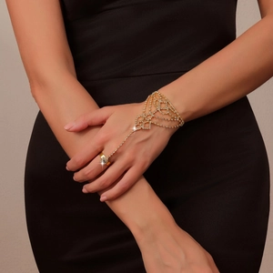 Close-up of a gold-plated hand chain with sparkling rhinestones on a female hand