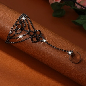 Macro view of rhinestone finger bracelet with sparkling black crystals on leather