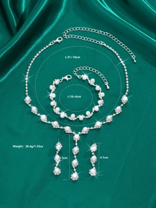 Detail view of sunflower rhinestone and pearl bridal jewelry set on green satin background