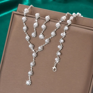 Elegant silver jewelry set with white faux pearls and rhinestones on green silk