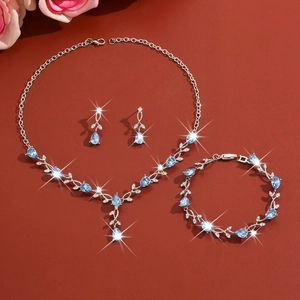 Detailed view of silver leaf jewelry set with blue teardrop stones and sparkling crystals