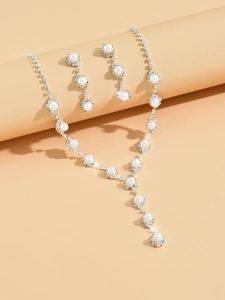 Detail view of sunflower rhinestone bridal jewelry set with pearls on warm background