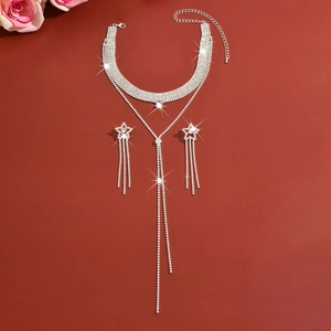Detail of silver rhinestone choker necklace and star tassel earrings set on red background