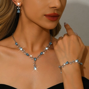 Elegant silver leaf jewelry set with blue teardrop zircon worn by a female model