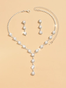 Macro shot of silver bridal jewelry set with white pearls and sparkling rhinestones