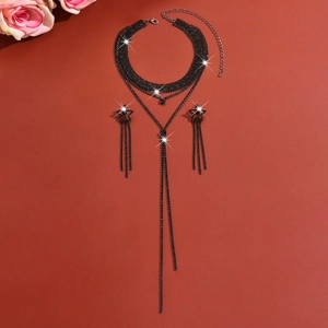 Exquisite black rhinestone choker necklace and star fringe earrings on red background