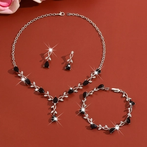 Detailed view of leaf jewelry set with black stones and sparkling crystals in silver