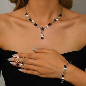 Close-up of elegant leaf-shaped jewelry set with black pear-cut zircons on a model