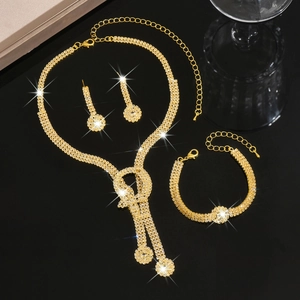 Detailed view of luxury gold bridal jewelry set with sparkling rhinestones and bow pendant