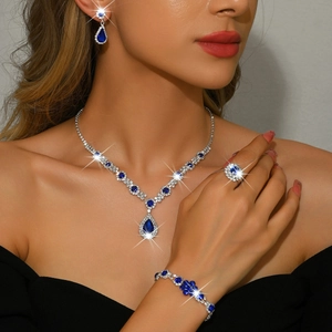 Detailed view of teardrop blue gemstone jewelry set worn with a black dress