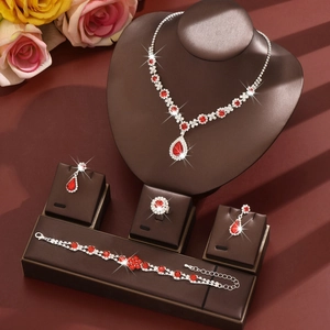 Bridal jewelry set with red teardrop crystals, including necklace, earrings, and ring