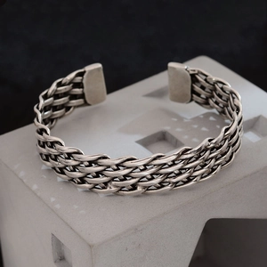 Minimalist vintage woven silver open bangle featuring a multi-layered twisted metal texture