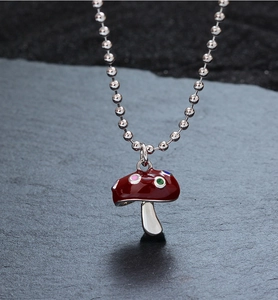 Vue détaillée du pendentif champignon en émail rouge avec pois colorés et chaîne argent