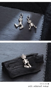 Detalle macro de un colgante de oso articulado de plata con zapatillas de cristal