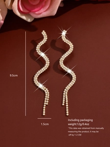Detail view of 9.5cm snake tassel earrings with gold finish and sparkling rhinestones