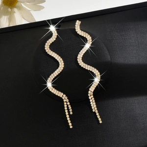Sparkling snake-shaped dangle earrings with rhinestones on a black background