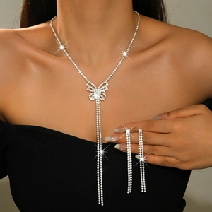 Macro detail of butterfly pendant necklace and tassel earrings set with rhinestones