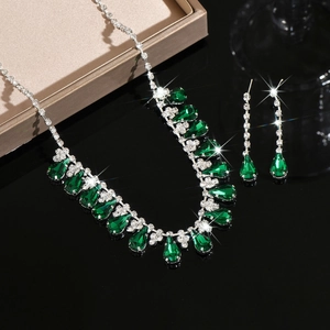 Detail of water-drop tassel necklace and earrings set with green gemstones and white crystals