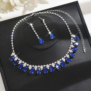 Detail of bridal jewelry set with dark blue pear-cut crystals on black velvet box