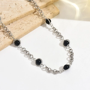 Chaîne de taille minimaliste en argent avec perles noires sur une chaîne de corps fine