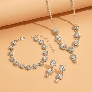 Detail of silver rhinestone bridal jewelry set featuring floral necklace and earrings
