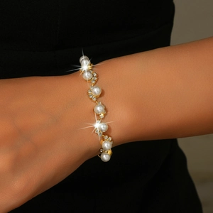 Close-up of elegant bridal pearl bracelet with golden sunflower rhinestone settings