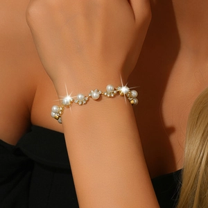 Detailed view of bridal bracelet with white pearls and sparkling rhinestone accents