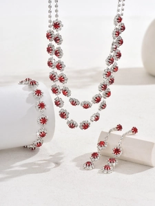 Macro shot of silver jewelry set with radiant round red gemstones and diamond halo decor