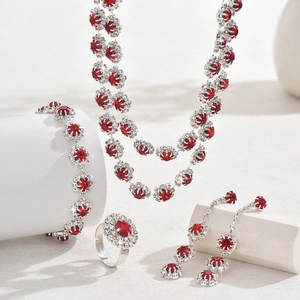Detail view of red crystal sunflower jewelry set on white geometric display props