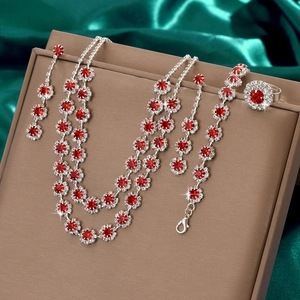 Detailed shot of bridal jewelry set with red gemstones on brown leather display