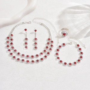 Detail view of a luxury bridal jewelry set with red stones and white rhinestones