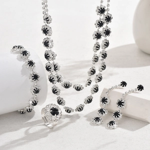 Detailed view of silver sunflower jewelry set featuring black gems and white diamonds