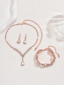 Détail d'une parure de bijoux de mariée en or rose avec cristaux et pendentifs en goutte