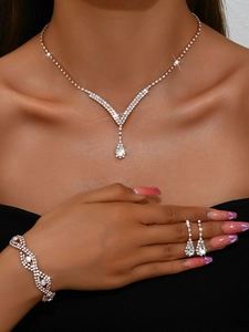 Détail de parure de mariage or rose avec collier en V et boucles d'oreilles sur modèle