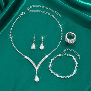 Ensemble de bijoux de mariée quatre pièces détaillé avec strass sur fond de soie verte