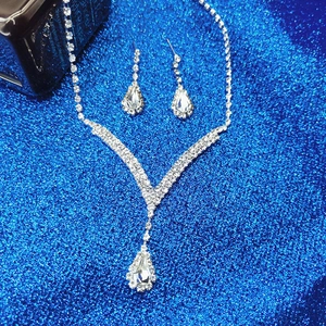 Détail d'une parure de bijoux de mariée argentée avec strass en poire et cristaux brillants