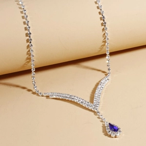 Détail du collier de mariée argenté avec strass ronds et pendentif goutte bleue