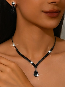 Macro shot of V-shaped rhinestone necklace with matching water-drop earrings for weddings