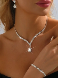 Close-up of elegant rhinestone bridal jewelry set with V-shaped necklace and pear drops