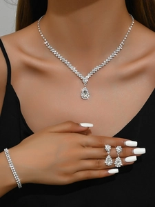 Detailed view of silver-tone bridal jewelry set with pear-cut crystals on a model