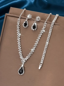 Detailed macro view of bridal jewelry set featuring black teardrop crystals and silver gems