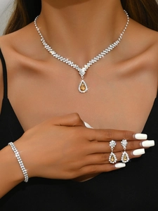 Close-up of bridal jewelry set with pear-cut champagne gemstones and sparkling rhinestones