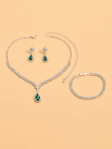 Detail shot of silver bridal jewelry set with green pear-shaped crystals and rhinestones