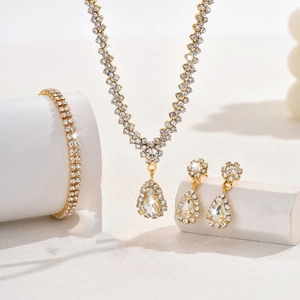 Close-up of gold-plated bridal jewelry set with sparkling crystals and waterdrop pendants