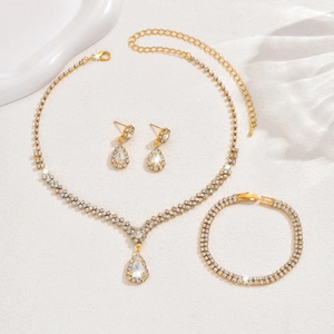 Detailed close-up of gold bridal jewelry set featuring sparkling rhinestones and drop crystals