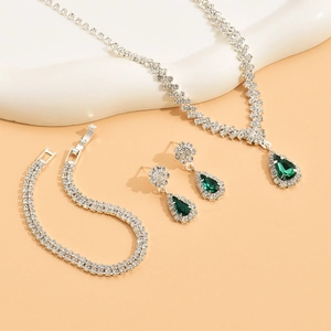 Macro view of bridal jewelry set with emerald pear-shaped gems and crystal accents