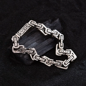 Pulsera de plata retro con patrón de dragón y mantra sánscrito sobre fondo de carbón