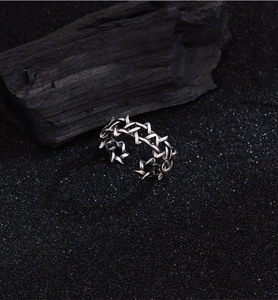 Detailed macro view of vintage silver hexagram ring with oxidation finish on black sand