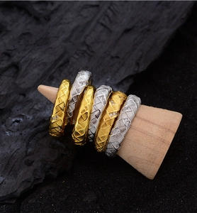 Makrodetail von Weizenstrukturringen mit Gold- und Silberfinish und Zirkonia-Besatz