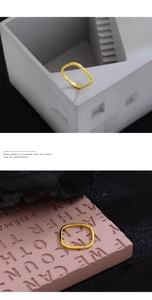 Detailansicht eines minimalistischen Goldrings mit Zirkon auf geometrischem Hintergrund